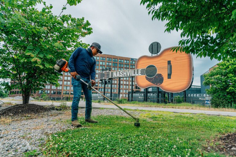 commercial landscape maintenance in front of large nashville sign